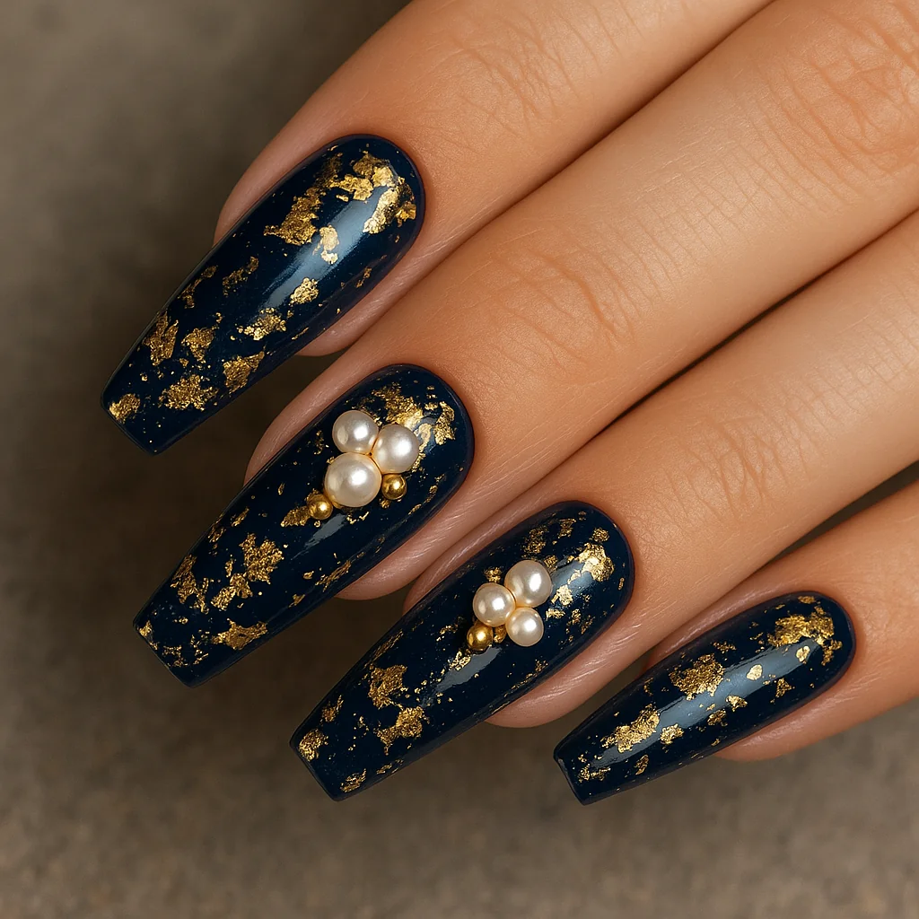 Maximalist nails with navy base, gold foil, and 3D pearl charms — nail art trend 2026