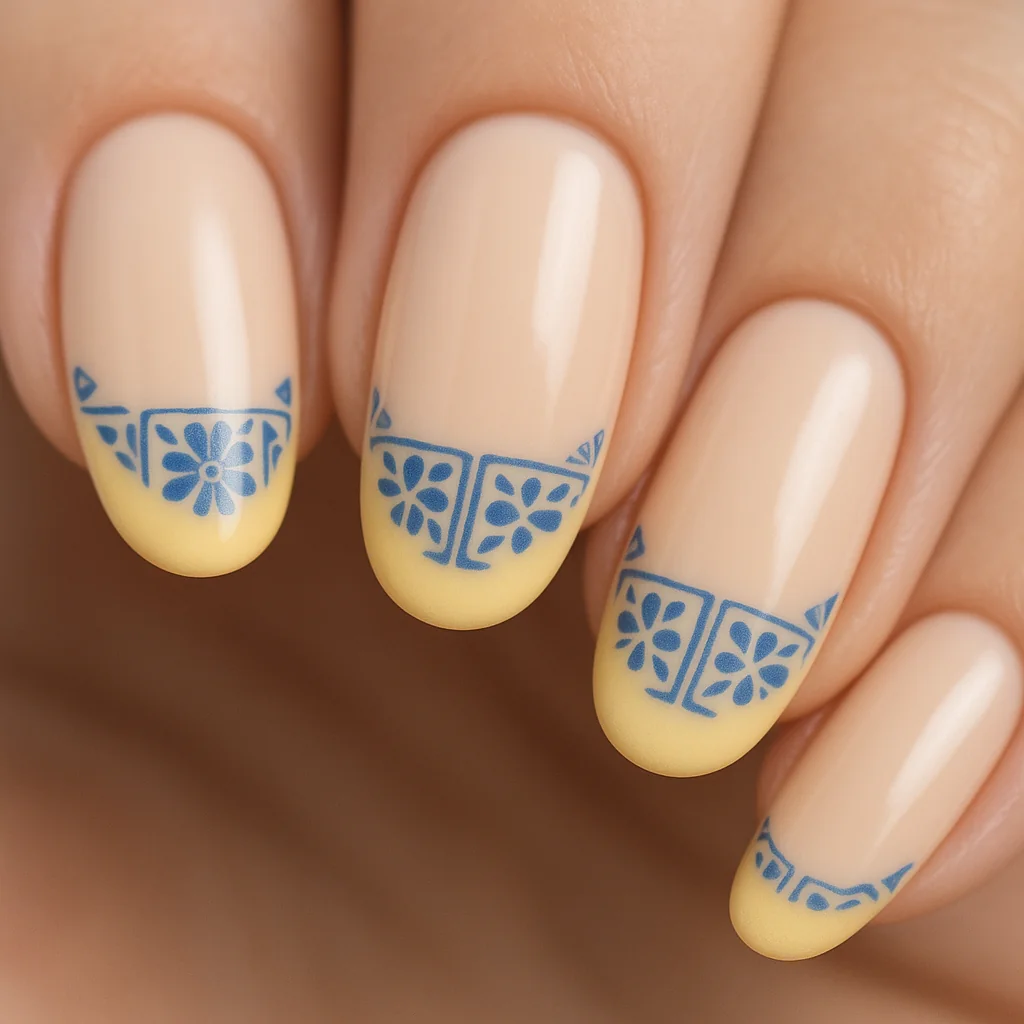 Lemon French tip nails with butter yellow tips and Mediterranean blue tile detail — nail trend 2026
