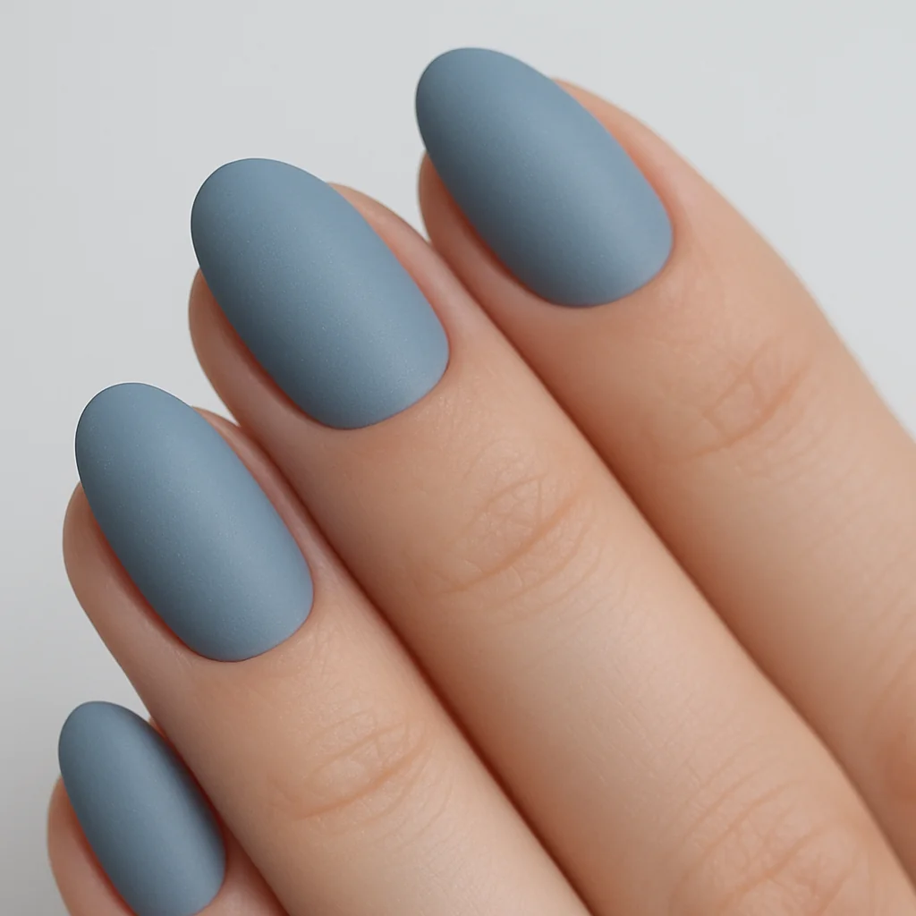 Foggy dusty steel blue semi-matte nails on short almond shape — cool minimalist summer nail color 2026